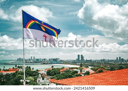 Recife, Pernambuco, Brazil. November, 19, 2016. The flag of Pernambuco waving at Alto da Sé. On the background, the cities of Olinda and Recife. Royalty-Free Stock Photo #2421416509