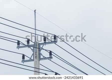 The top of the electric pole and wires have a sky background.