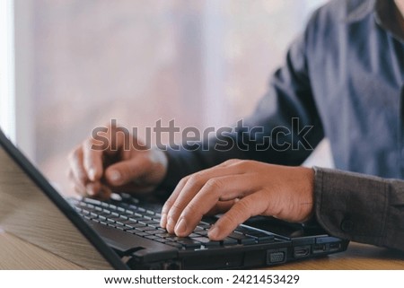 Businessman's hands work with a notebook computer on an office table or office with free space for text.