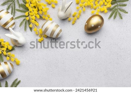 Mimosa branch, Easter eggs on gray concrete background.  Beautiful Easter spring background with place for text.