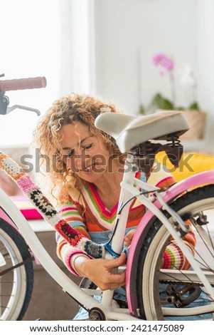 Beautiful caucasian young woman modifying a bike at home with handcrafted tailors art materials - people and colors with crazy art lifestyle - happiness working handmade
