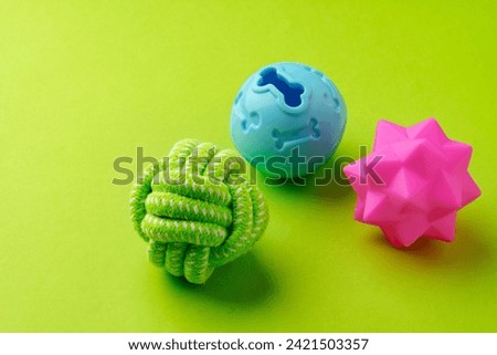 Colorful pet toys balls on green background close up