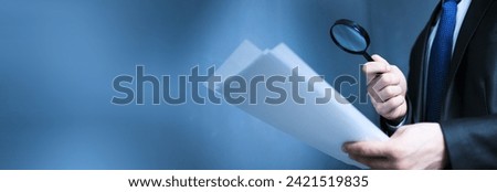 Man hand magnifier and document on dark background
