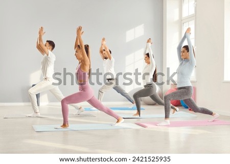 Dedicated happy sports team engaging in a group yoga session at the fitness gym. The shared happiness, active lifestyle, and commitment to fitness, perfect portrayal teamwork and wellness in action. Royalty-Free Stock Photo #2421525935