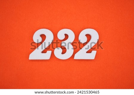Orange felt is the background. The numbers 232 are made from white painted wood. Royalty-Free Stock Photo #2421530465