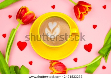 Top view coffee cup, red hearts and tulips on pink background. Spring good morning card.