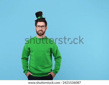 St. Patrick's day party. Man in leprechaun hat on light blue background. Space for text