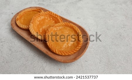 Pie Susu Bali with creamy milk custard topping on wooden plate isolated on grey background. Indonesian food