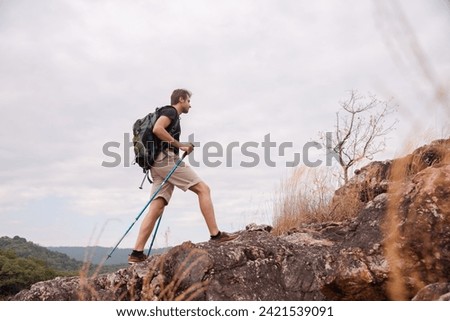 Healthy male successfully hiking walking to the top of mountain in holiday autumn alone, backpack tourist man happy exercise outdoors adventure trip traveling lifestyle, business achievement concept