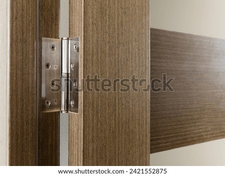 Door hinge on a wooden interior door with glass inserts. Royalty-Free Stock Photo #2421552875