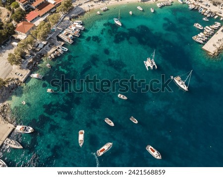 Aerial drone photo of Agios Nikolaos - a small port on the island of Zante.  Port on a Greek island with blue turquoise water with many boats and yachts on the water in Greece, Zakynthos.