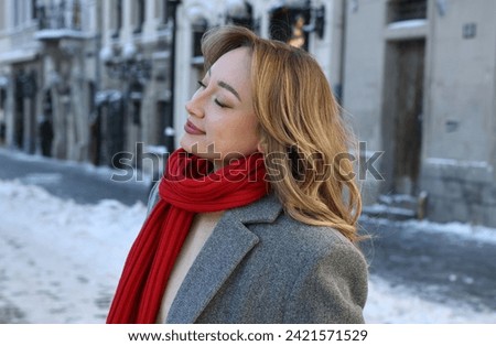 Portrait of charming woman on city street in winter
