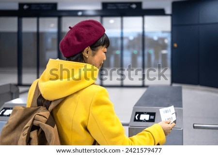 Female passenger with backpack validating boarding pass ticket at the airport. Royalty-Free Stock Photo #2421579477