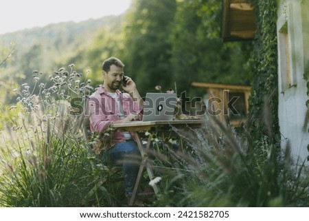 Man working in the garden on laptop, phone calling. Businessman working remotely from outdoor homeoffice, thinking about new business or creative idea.