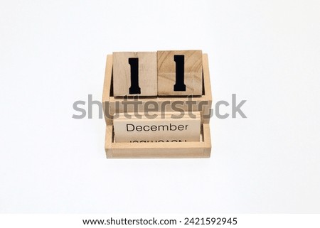 Close up of a wooden perpetual calendar showing the 11th of December. Shot close up isolated on a white background 