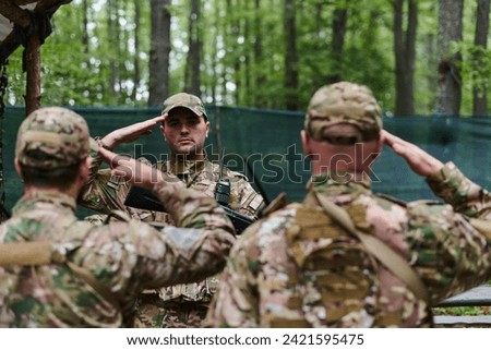 A dedicated soldier salutes his elite unit, showcasing camaraderie and readiness for the most perilous military operations Royalty-Free Stock Photo #2421595475