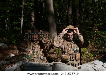  two elite soldiers meticulously prepare for a dangerous military operation, embodying strategic readiness, discipline, and teamwork as they gear up for a mission fraught with intensity and peril. Royalty-Free Stock Photo #2421595719