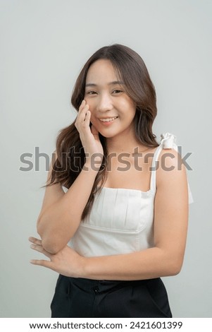 Portrait of a beautiful young Asian girl applying dry powder Makeup with cosmetic cushion on her face with mascara placed on eyelashes on white background, makeup concept