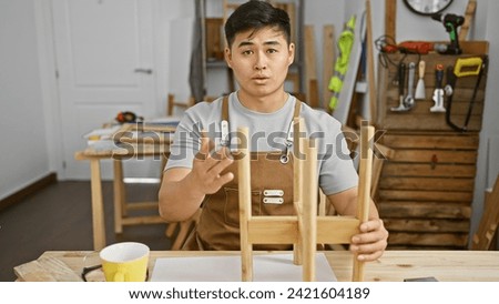 A young asian man works in a carpentry workshop, showing craft, skill, and dedication.