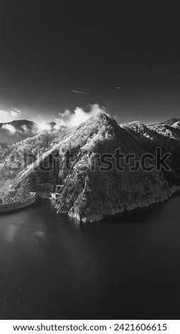 Beautiful mountain landscape in cold season. Black And White Winter landscape. Infrared photography. Mountain peak with a mountain lake covered with lichen. Frost forest on the mountain. 
