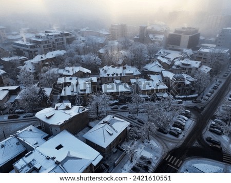 Aerial photography over Bucharest city. Fly over Bucharest City in winter season. Snowy day over blocks, streets and parking lot. Blizzard day in the city. Frozen block of flats in Bucharest. 