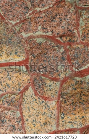 It's close up view of red and yellow stones of wall. This is pink stone wall of building. It is view of  stone wall of castle. It is a view of stone wall texture.