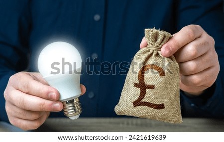 British pound sterling money bag and burning idea light bulb in the hands of a man. Investment in an idea. Offering financial incentives to enhancing energy efficiency. Reduce carbon footprint