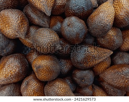 A bunch of snake fruit for sale at the supermarket. Close up view, selective focus. Use for textured background