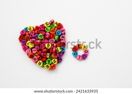 Phrase love you next to a heart formed with colorful beads to make necklaces and bracelets