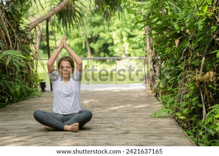 Little girl child doing yoga exercise relax in the park. stretching on the grass summer day