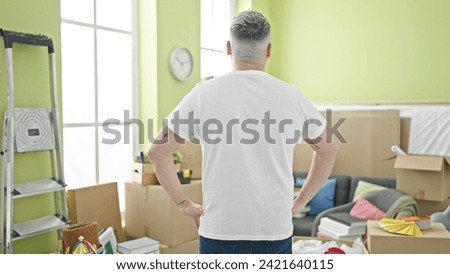 Young caucasian man standing backwards at new home