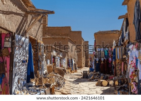 Souvenir shop with carpets, traditional clothes and other things in clay town of Ait Ben Haddou, Morocco Royalty-Free Stock Photo #2421646101