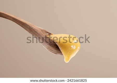 Royal jelly in honey in wooden spoon Royalty-Free Stock Photo #2421661825