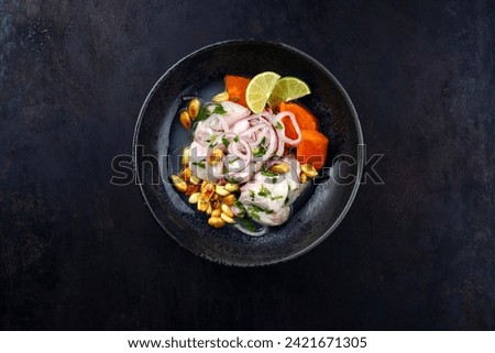 Traditional Peruvian gourmet ceviche sea bass filet piece with sweet potatoes and cancha marinated and served in lime sauce as top view in a modern design bowl with copy space