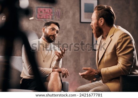 two attractive bearded men in elegant stylish attires sitting and discussing interview questions