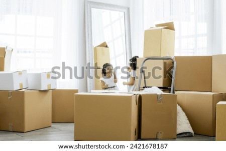 Selective focus on little caucasian cute sweet curly hair girl playing and standing with unpacking paper boxes for moving to new comfortable house or home or apartment with fun and happiness Royalty-Free Stock Photo #2421678187