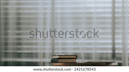 Close-up of a simple workspace with a laptop, notebook