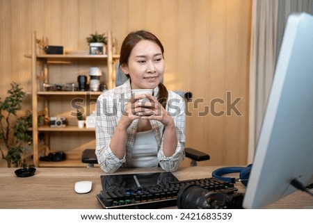 Female video editor works indoors in creative office studio. Royalty-Free Stock Photo #2421683539
