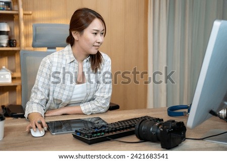 Female video editor works indoors in creative office studio. Royalty-Free Stock Photo #2421683541
