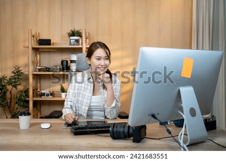 Female video editor works indoors in creative office studio. Royalty-Free Stock Photo #2421683551