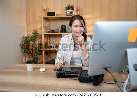 Female video editor works indoors in creative office studio. Royalty-Free Stock Photo #2421683561