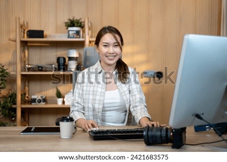 Female video editor works indoors in creative office studio. Royalty-Free Stock Photo #2421683575