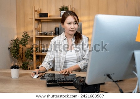 Happy female video editor works indoors in creative office studio. Royalty-Free Stock Photo #2421683589