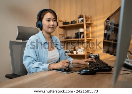 Confident female photo editors sitting in creative workplace front of personnel computer and smiling to camera.