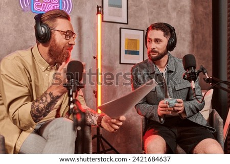 good looking interviewer in casual attire discussing questions with his young guest during podcast