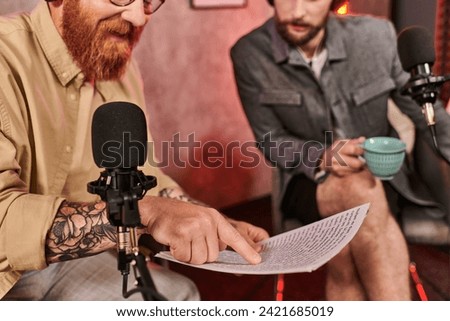 handsome interviewer in everyday attire discussing questions with his guest during podcast