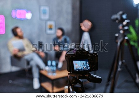 focus on camera filming stylish blurred men with beards in headphones discussing questions, banner