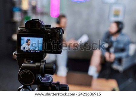 focus on camera filming handsome blurred men with beards in headphones discussing questions, banner