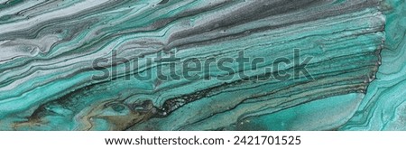art photography of abstract marbleized effect background with turquoise, green and blue creative colors. Beautiful paint.