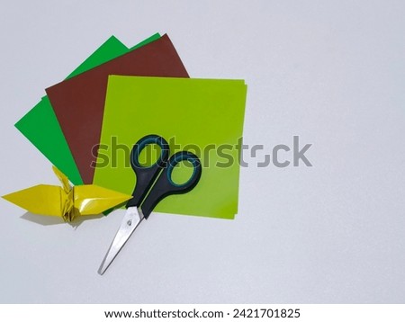 scissors and origami paper on a white background